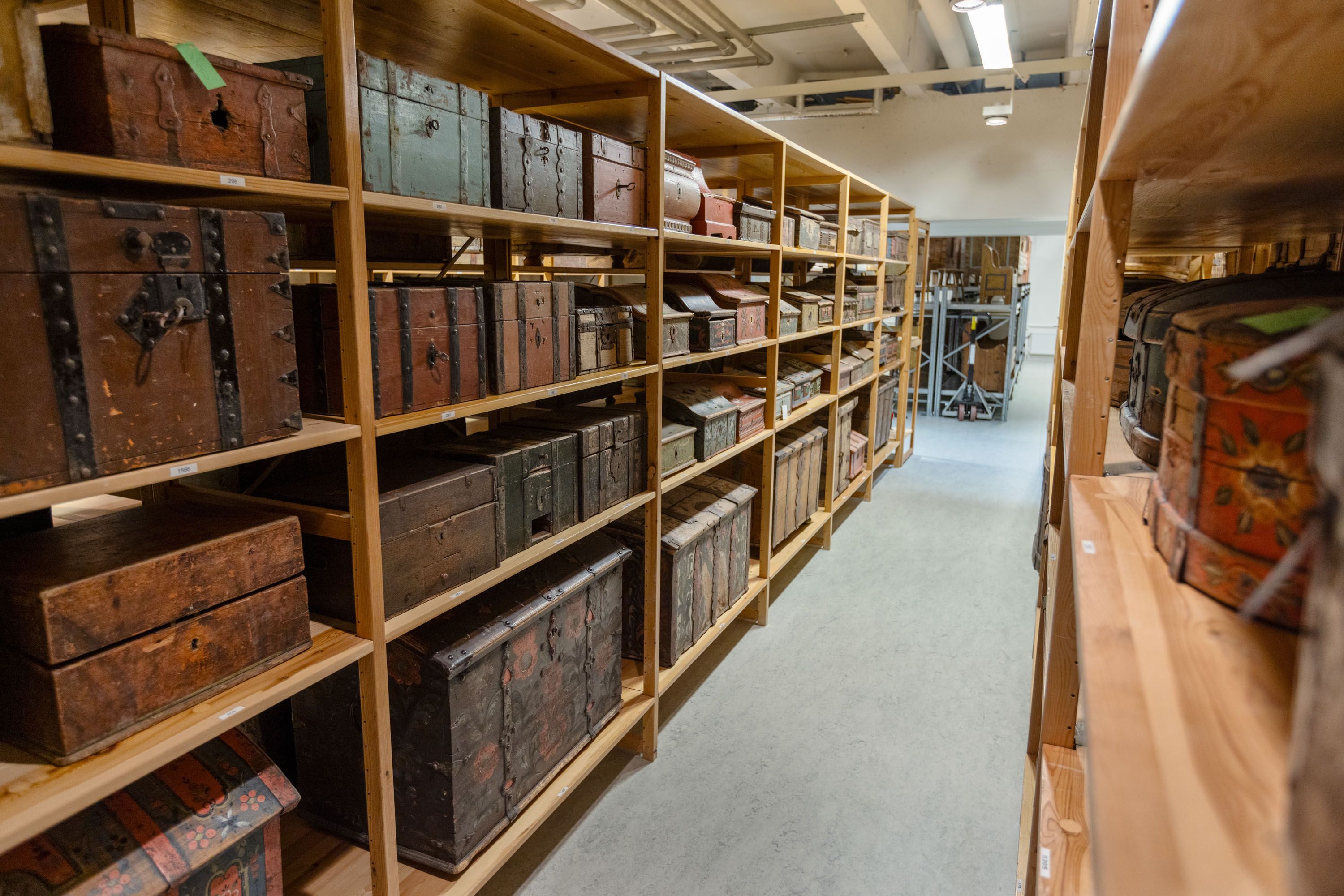 Rum med museets föremålssamling. På hyllorna närmast i bild står flera olika kistor.